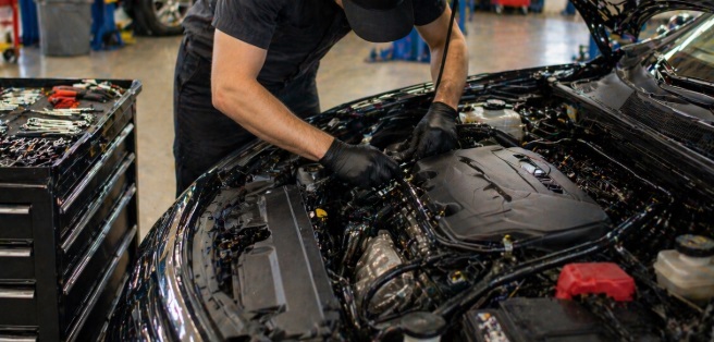 Philadelphia, PA auto repair technician working on car engine in garage